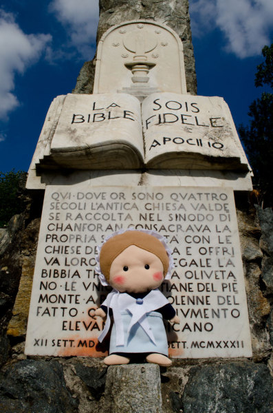 Valdesina ed un particolare del monumento che raffigura la Bibbia tradotta